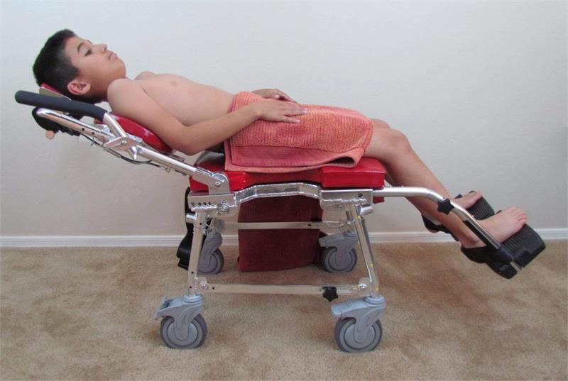 Fully reclined shower and commode chair with adjustable leg rests