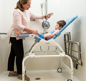 Rifton Shower Stand for the Wave Bathing Chair to easily roll into your shower.|Photo of Rifton Wave Bathing Chair attached to the Shower Stand, reducing back strain.