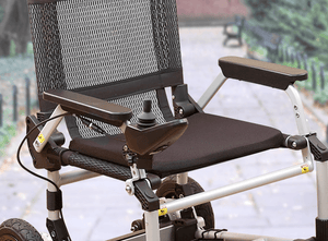 Zoomer - Black|Zoomer - Blue|Quick guide to the Zoomer|Lightweight 52# and easy to drive inside or outside|Joystick comes standard on right but can easily remount on the left by user|Comfort Seating|25 inch turning radius for easy indoor turns|Easy to fold - step 1 pull the cable|Easy to fold - step 2 fold the chair|Easy to fold - step 3 roll away|Slide up to the table or desk with no problem||Easily Scales up to a 10° incline|Fits in nearly any vehicle within seconds